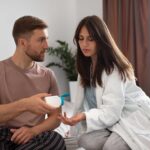 Medico discute degli integratori per il vigore maschile con paziente in uno studio.